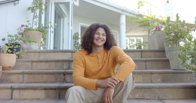 Young Man Smiling While Sitting on Outdoor Steps - Download Free Stock Images Pikwizard.com