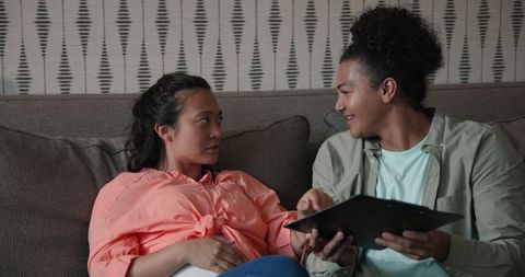 Couple smiling together while planning wedding on couch