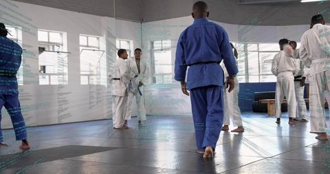 African american martial artist walking in blue gi in modern judo dojo during class