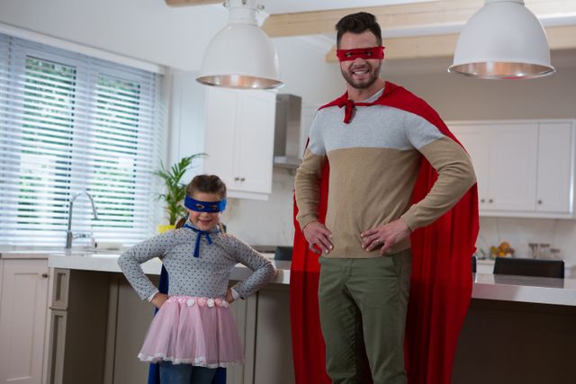 Portrait of father and daughter pretending to be superhero at home