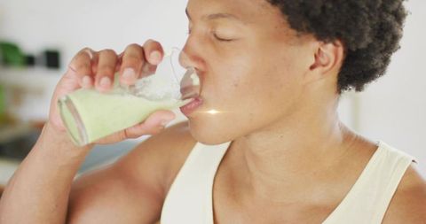 Young Man Drinking Green Smoothie in Modern Kitchen for Healthy Lifestyle