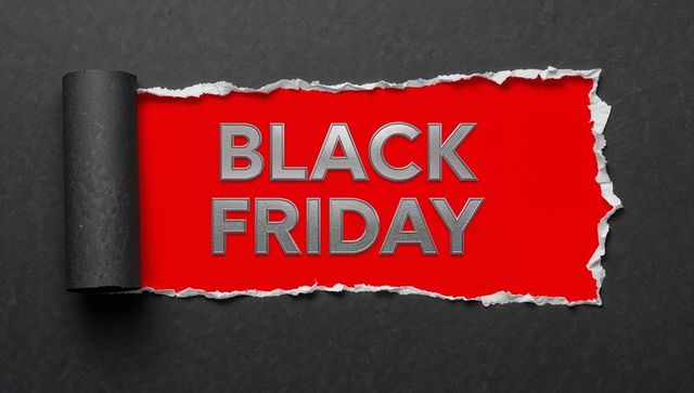 Torn black paper rolling back revealing metallic black friday typography on red panel