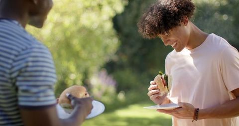 Relaxed Friends Enjoying Casual Lunch Outdoors in Sunlit Garden