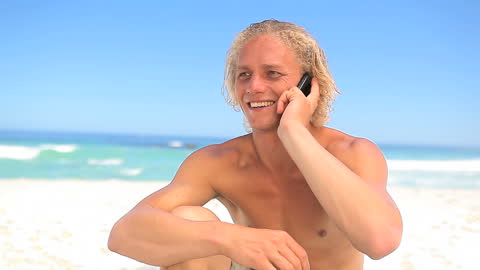Smiling Man on Beach Enjoying Phone Conversation