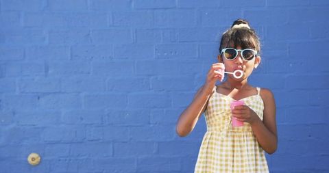 Young Girl Blowing Bubbles in Schoolyard with Playful Expression - Download Free Stock Images Pikwizard.com
