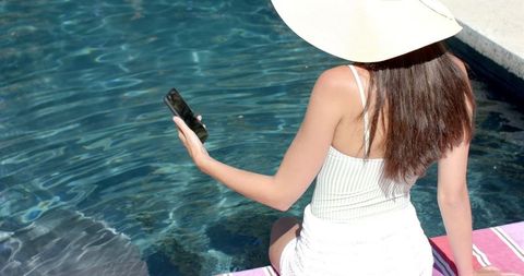 Caucasian Girl Relaxing with Smartphone by Pool on Sunny Day - Download Free Stock Images Pikwizard.com