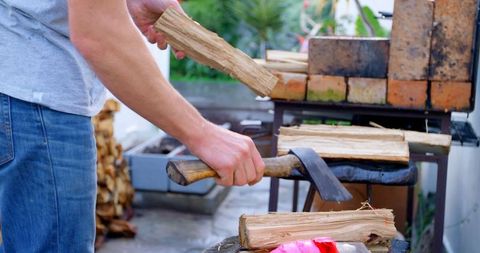 Male lumberjack chopping firewood outdoors