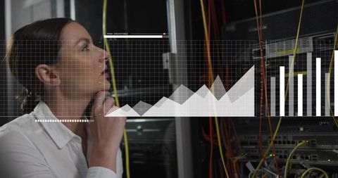 Female network engineer analyzing server data with analytics overlays in server room rack