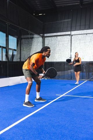 Diverse Partners Enjoy Padel Tennis Match on Vibrant Blue Court