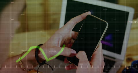 Man Tracking Financial Data on Mobile Phone and Laptop