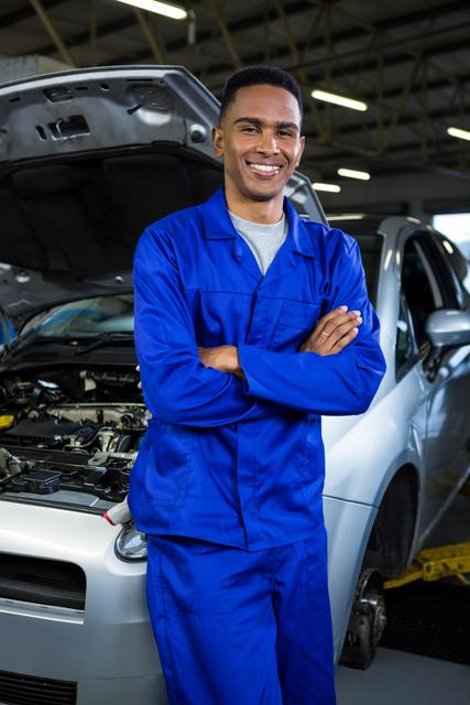 Portrait of mechanic standing with arms crossed at repair garage