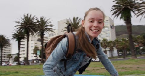 Joyful Girl Biking in Urban Park with Palm Trees