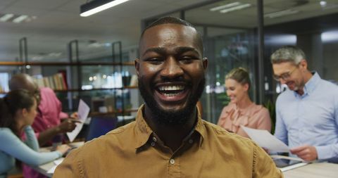 Happy African American Businessman with Diverse Team in Modern Office