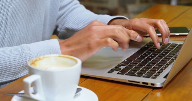 Man Typing on Laptop in Coffee Shop with Cup of Coffee - Download Free Stock Images Pikwizard.com