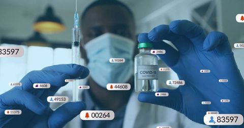 Masked doctor with covid-19 vaccine vial and syringe in lab