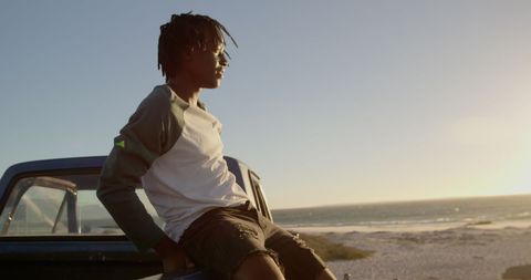 Young Man Relaxing on Pickup Truck by the Beach