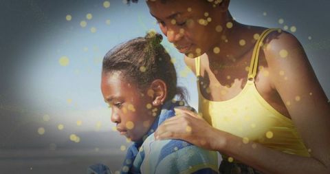 Mother Comforting Child by Seaside with Vibrant Beach Towel