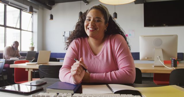 Smiling Woman Working in Modern Office with Notebooks and Laptop - Download Free Stock Images Pikwizard.com