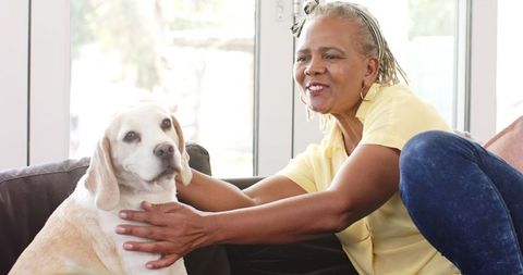 Senior woman enjoying relaxed moment with pet dog at home