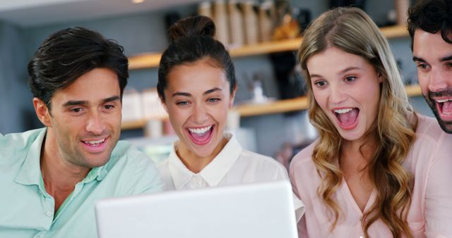 Group of young adults gathered around laptop in cafe smiling and expressing excitement. Ideal for illustrating themes of friendship, teamwork, technology use, social gatherings, and positive emotions. Can be used in marketing materials for cafes, tech products, educational content, or social media promotions.