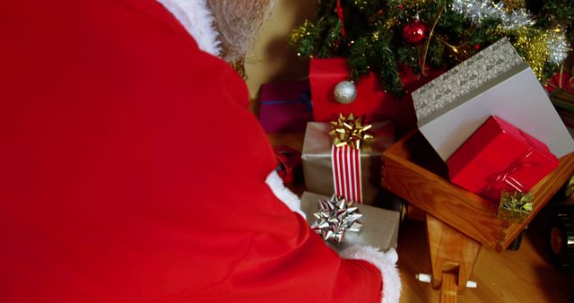 Santa Claus Placing Decorated Christmas Presents Under Tree - Download Free Stock Images Pikwizard.com