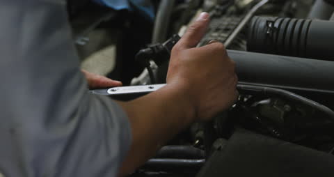 Car Mechanic Using Wrench in Workshop