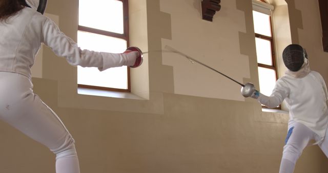 Fencing duel between athletes in protective gear indoors - Download Free Stock Images Pikwizard.com