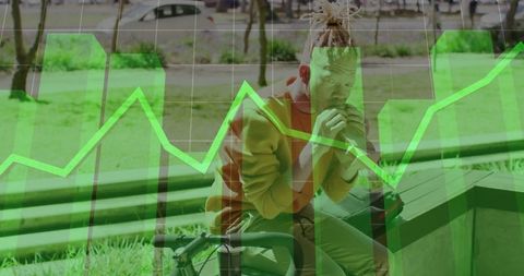 Young man in urban park overlaid with green financial graph