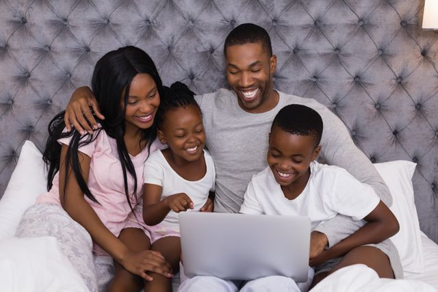 Happy African American Family Enjoying Laptop on Bed Together - Download Free Stock Photos Pikwizard.com