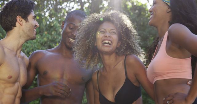 Group of young multiracial friends laughing together on a sunny day. Perfect for themes of friendship, joy, summer adventures, outdoor activities, and youth lifestyle marketing. Can be used to promote summer events, social gatherings, and relatable lifestyle content for young audiences.