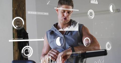 Mid-adult man checking fitness band during indoor cycling with augmented reality hud