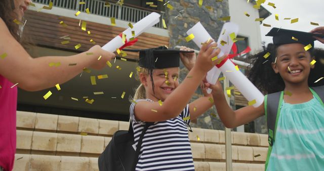 Smiling children celebrating graduation outdoors, holding diplomas with golden confetti falling around them. Ideal for depicting educational milestones, joyful moments, school achievements, and childhood celebrations in promotional materials, educational articles, and celebratory event flyers.