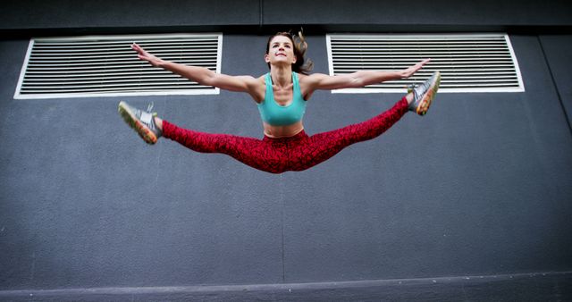 Energetic Woman in Athletic Wear Performing High Jump Split - Download Free Stock Images Pikwizard.com