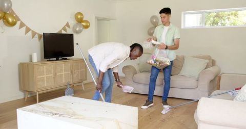 Friends collaborating to clean party decorations at home