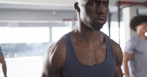 Focused African American Athlete Training in Gym Wearing Navy Tank Top Showing Muscular Torso