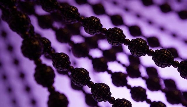 Ornate filigree bead strands crossing purple backlight showcasing abstract jewelry detail