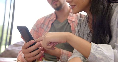 Couple Enjoying Relaxed Moment Sharing Content on Smartphone