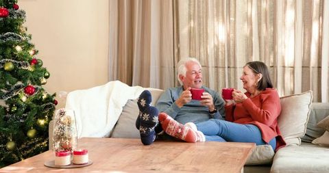 Senior Couple Relaxing with Hot Beverages during Christmas Holidays