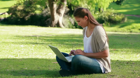 Young Woman Typing on Laptop Enjoying a Day in the Park