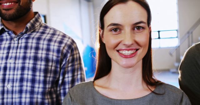 Smiling Woman in Office Setting with Colleagues - Download Free Stock Images Pikwizard.com