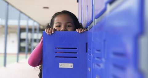 Curious Girl Peeking from Blue School Locker