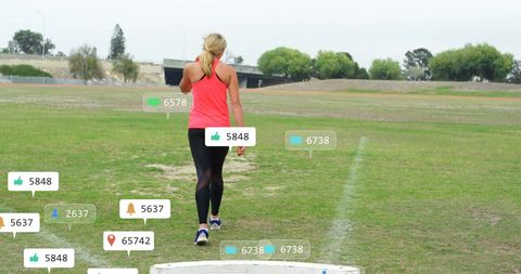 Woman Walking on Sports Field with Social Media Notifications Overlay - Download Free Stock Images Pikwizard.com