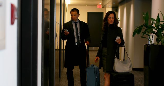 Biracial business people using mobile phone near elevator in a modern hotel. Biracial business people waiting for elevator 4k