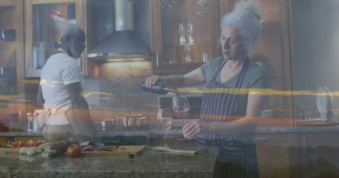 Senior Couple Cooking Together in Rustic Kitchen Pouring Wine