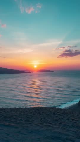 Sun Descending Over Calm Sea with Shimmering Path, Vertical Tilt Revealing Rocky Shore