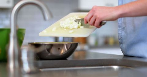 Man chopping vegetables in modern kitchen for meal prep