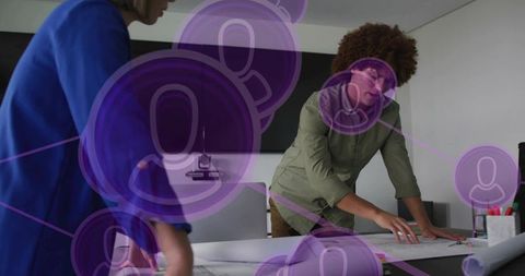 Collaborative team leaning over blueprints with purple network overlay planning strategy