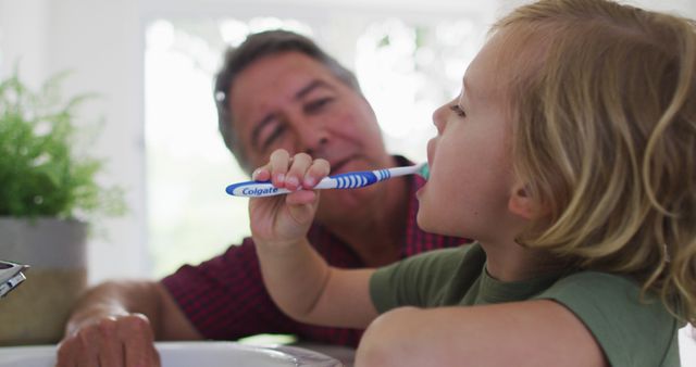 Caucasian grandfather helping his grandson to brush his teeth at home - Download Free Stock Photos Pikwizard.com