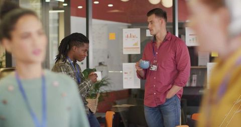 Modern office lifestyle: colleagues engaging in relaxed coffee chat
