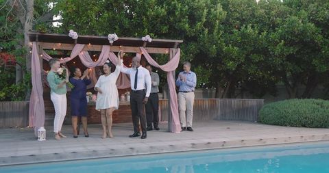 Seniors Celebrating by Poolside at Festive Garden Gathering